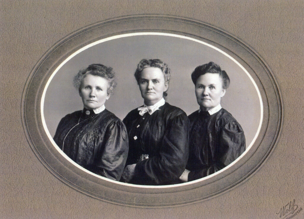Three women in formal dresses pose for a vintage studio portrait in a round frame.